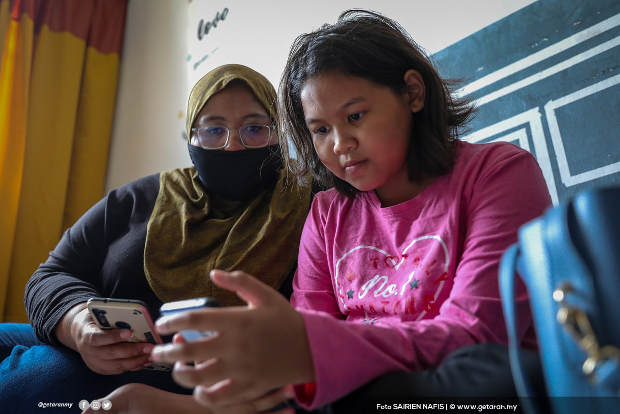 Nur Alya Aqillah Zamzuri, 12, dibantu ibunya ketika sesi PdPR di Flat Lembah Subang. - SAIRIEN NAFIS/Foto Getaran, 22 Januari 2021