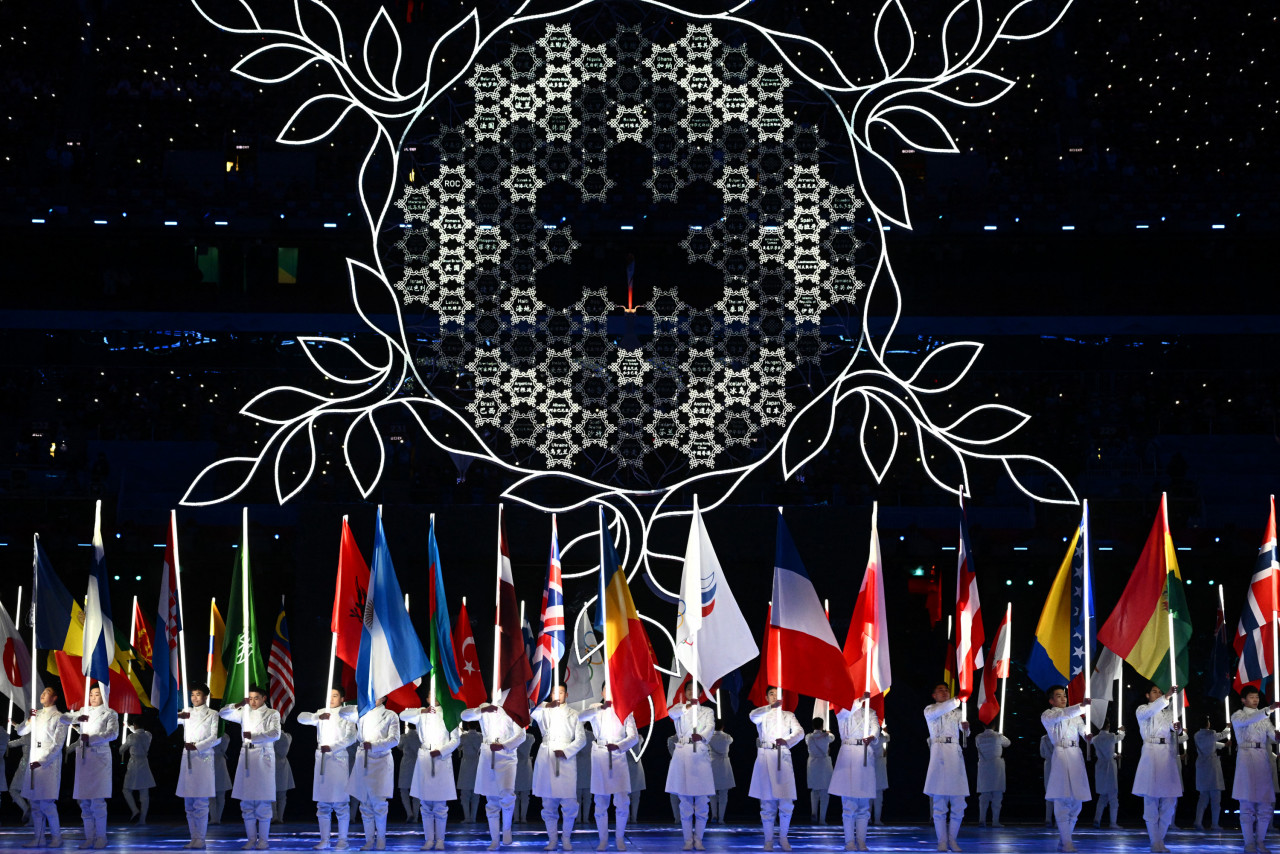 Sukarelawan membawa bendera negara yang bertanding pada Sukan Olimpik Musim Sejuk pada majlis penutupan, malam tadi. - Gambar AFP