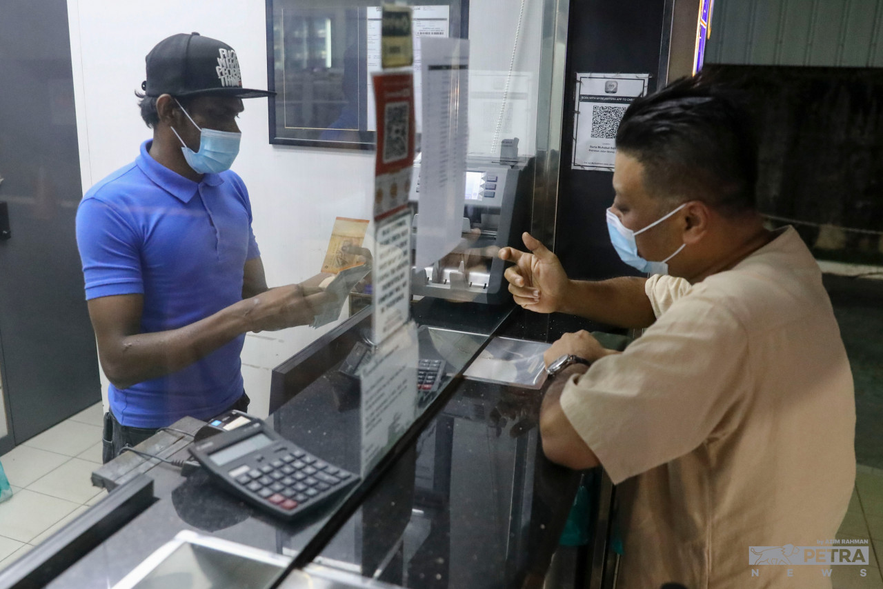 Seorang lelaki menukar wang di premis penggurup mata wang di Johor Bahru.