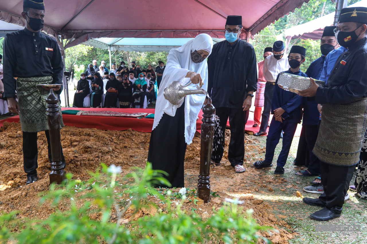 Isteri Allahyarham, Salbiah Tunut menyiram air mawar dipusara suaminya - Gambar oleh Sairien Nafis