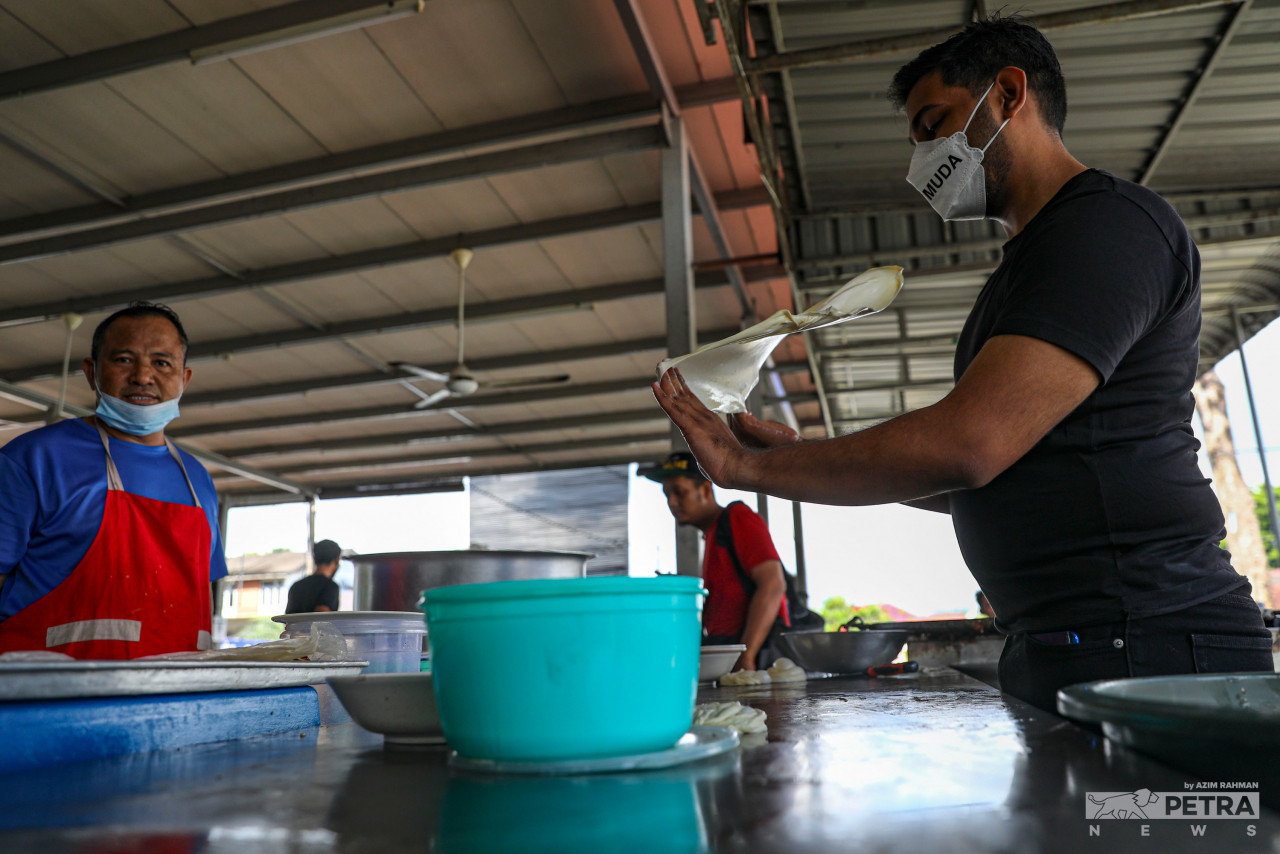 Rasid menebar roti canai, ketika sesi bertemu pengundi di DUN Larkin. - Gambar Azim Abd Rahman