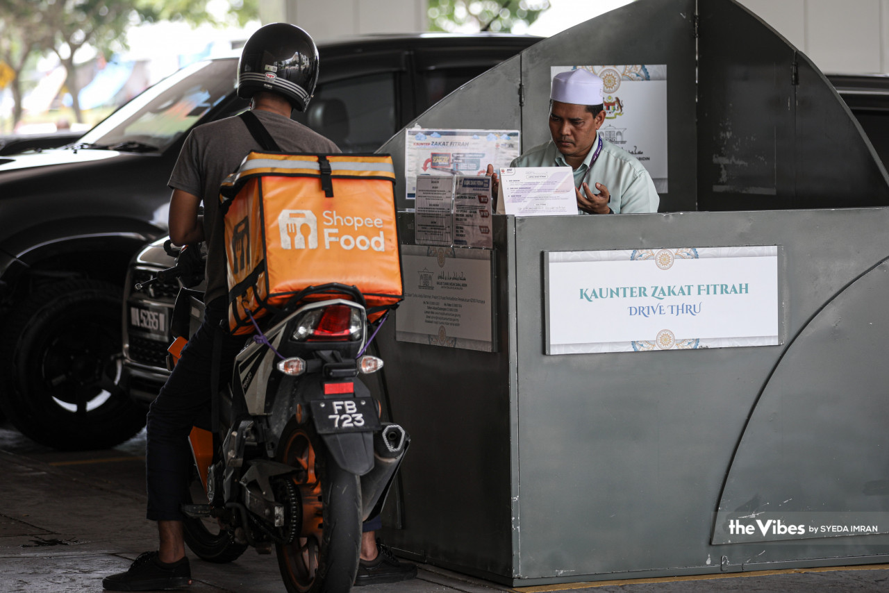 Meskipun sibuk dengan penghantaran barang dan makanan, namun lelaki ini tidak lupa akan kewajipan membayar zakat fitrah menerusi kaunter zakat 'drive thru' di Masjid Tuanku Mizan Zainal Abidin, Putrajaya.