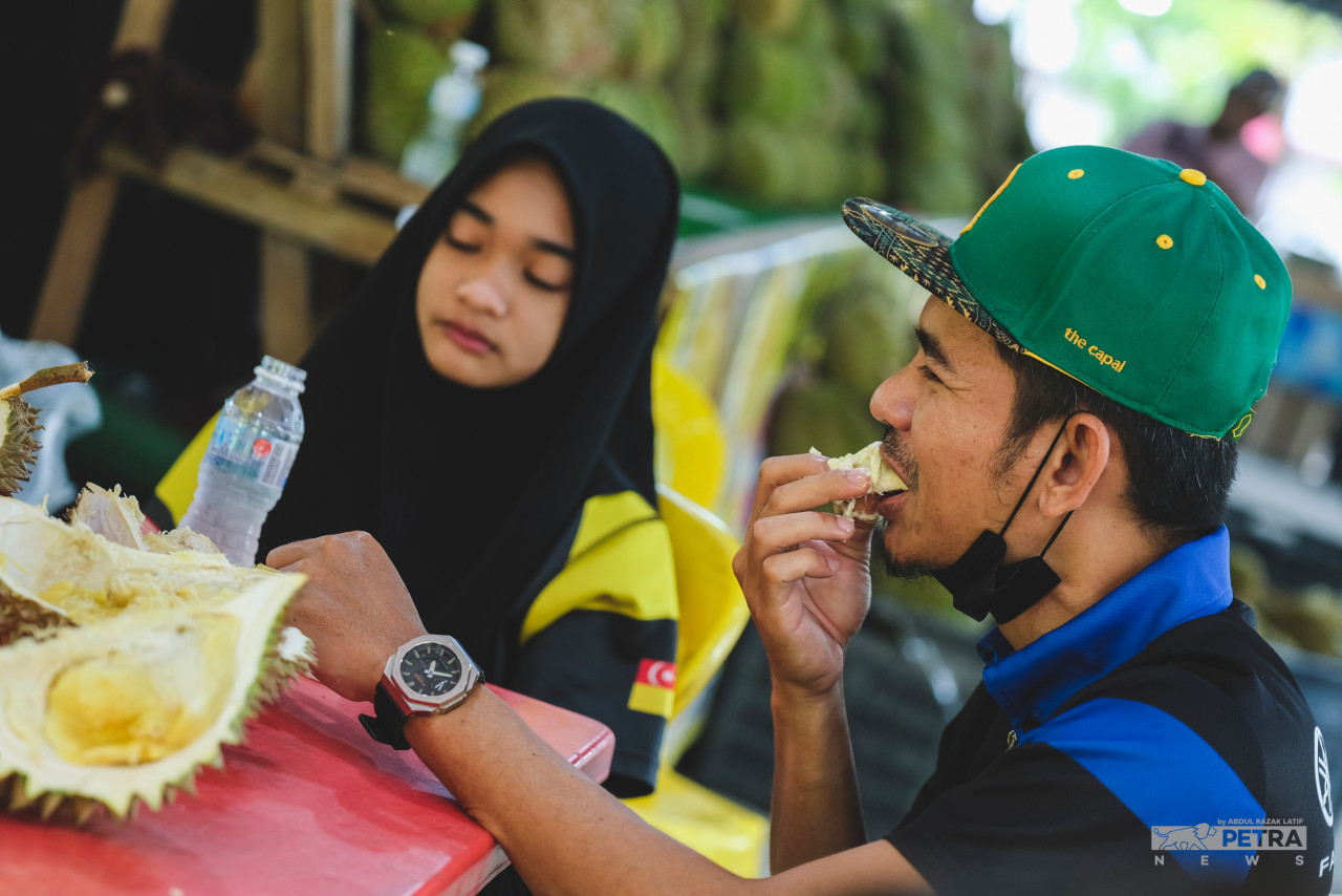 Menikmati durian di tempat buah itu dijual memberi lebih nikmat kepada peminat raja buah itu. - Gambar oleh Abd Razak Latif