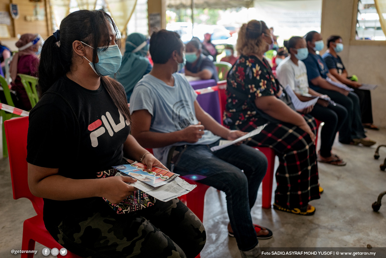 Orang Asli suku Temuan dari Kampung Orang Asli Pulau Kempas ini menunggu giliran untuk menerima dos pertama vaksin COVID-19.