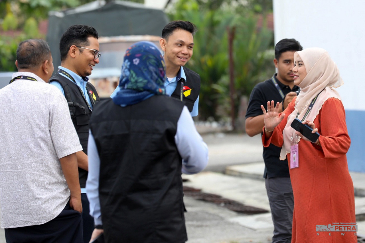 Calon Pakatan Harapan Dewan Undangan Negeri Hulu Kelang, Juwairiya Zulkifli berbual dengan petugas Suruhanjaya Pilihan Raya di pusat undi awal di Balai Polis Hulu Klang. gambar Salwa Farhana Ismail
