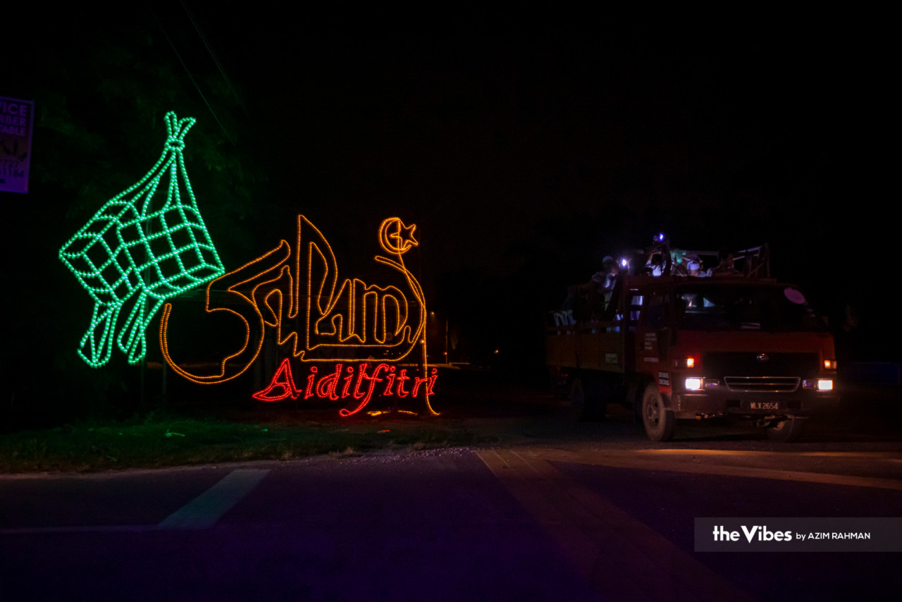 Dekorasi lampu ketupat dan ucapan Selamat Hari Raya di jalan masuk Kampung Jenjarom.