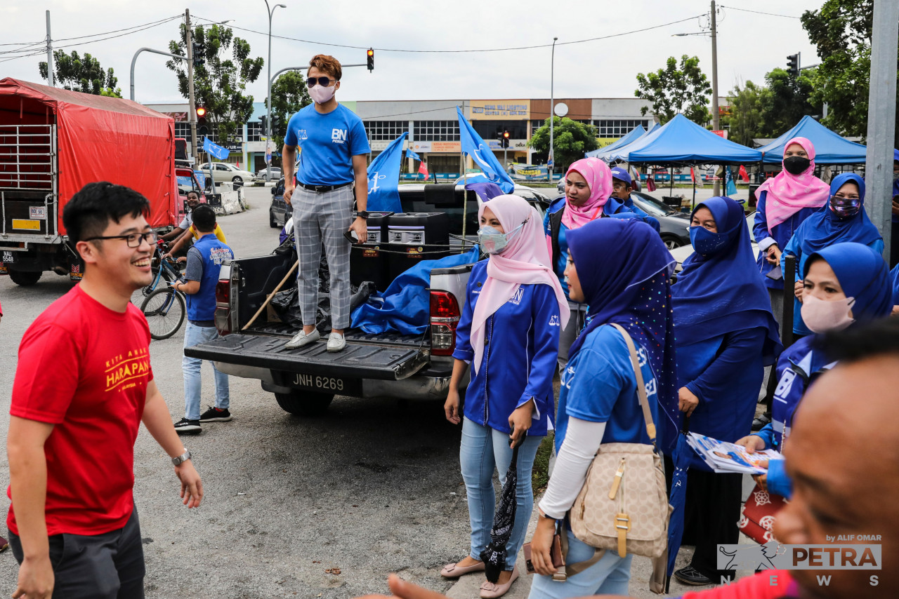 Lee yang tidak kekok dilihat turut beramah mesra dengan petugas-petugas BN di pasar malam Desa Aman, Ipoh. - Gambar Alif Omar