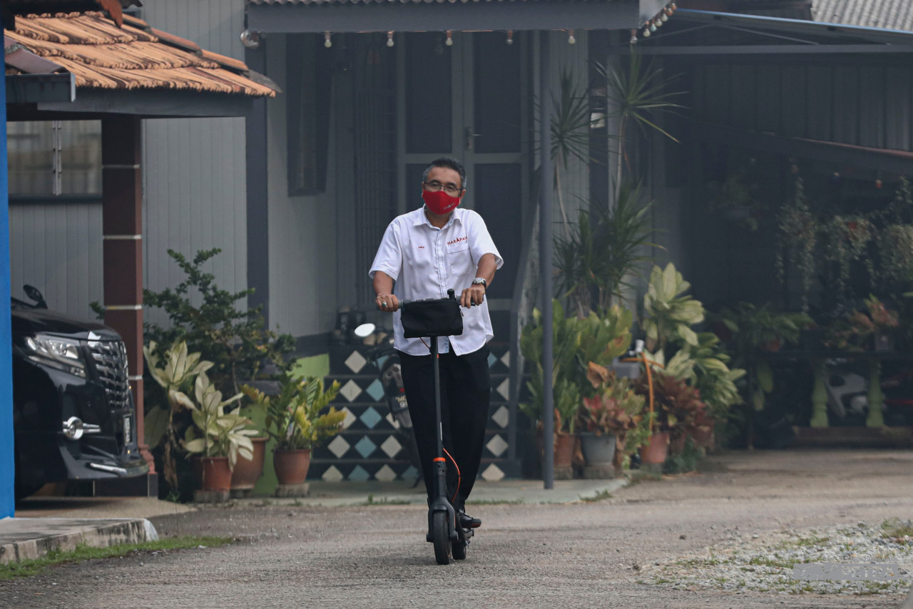 Adly Zahari menaiki skuter di Bukit Baru.