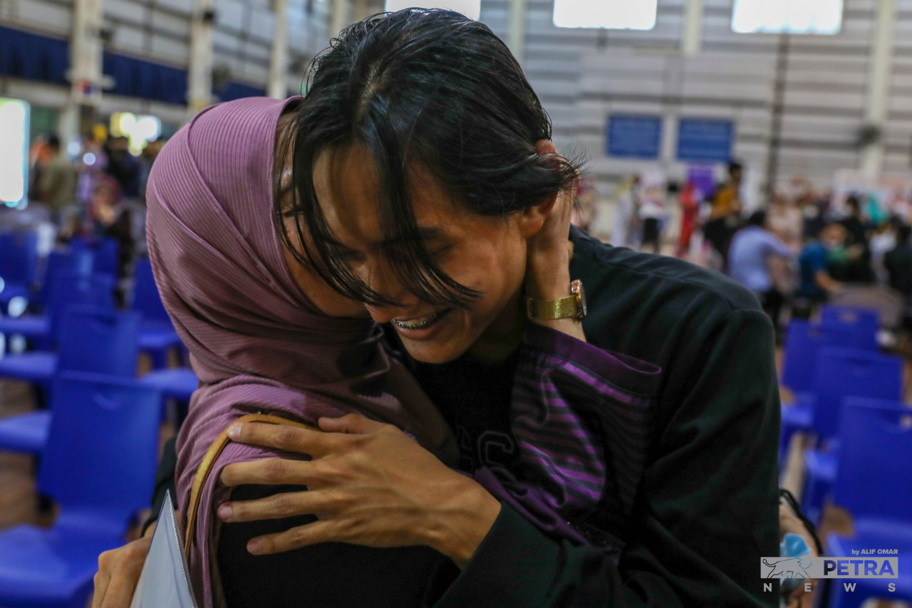 Calon SPM 2021 ini dipeluk erat ibunya selepas memperoleh keputusan SPM di SMK Putrajaya Presint 11(1), hari ini. - Gambar oleh Alif Omar