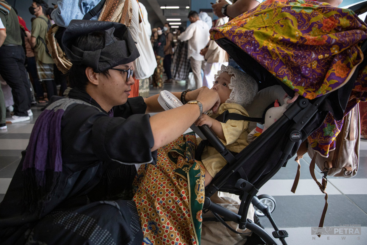 Kanak-kanak ini turut mengambil bahagian bersama bapanya dalam Keretapi Sarong 2022 .