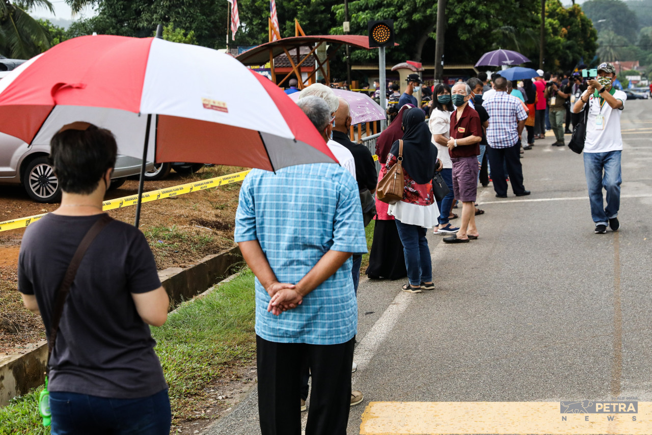 Orang ramai beratur untuk mengundi di Sekolah Kebangsaan Sungai Udang. - Gambar Alif Omar