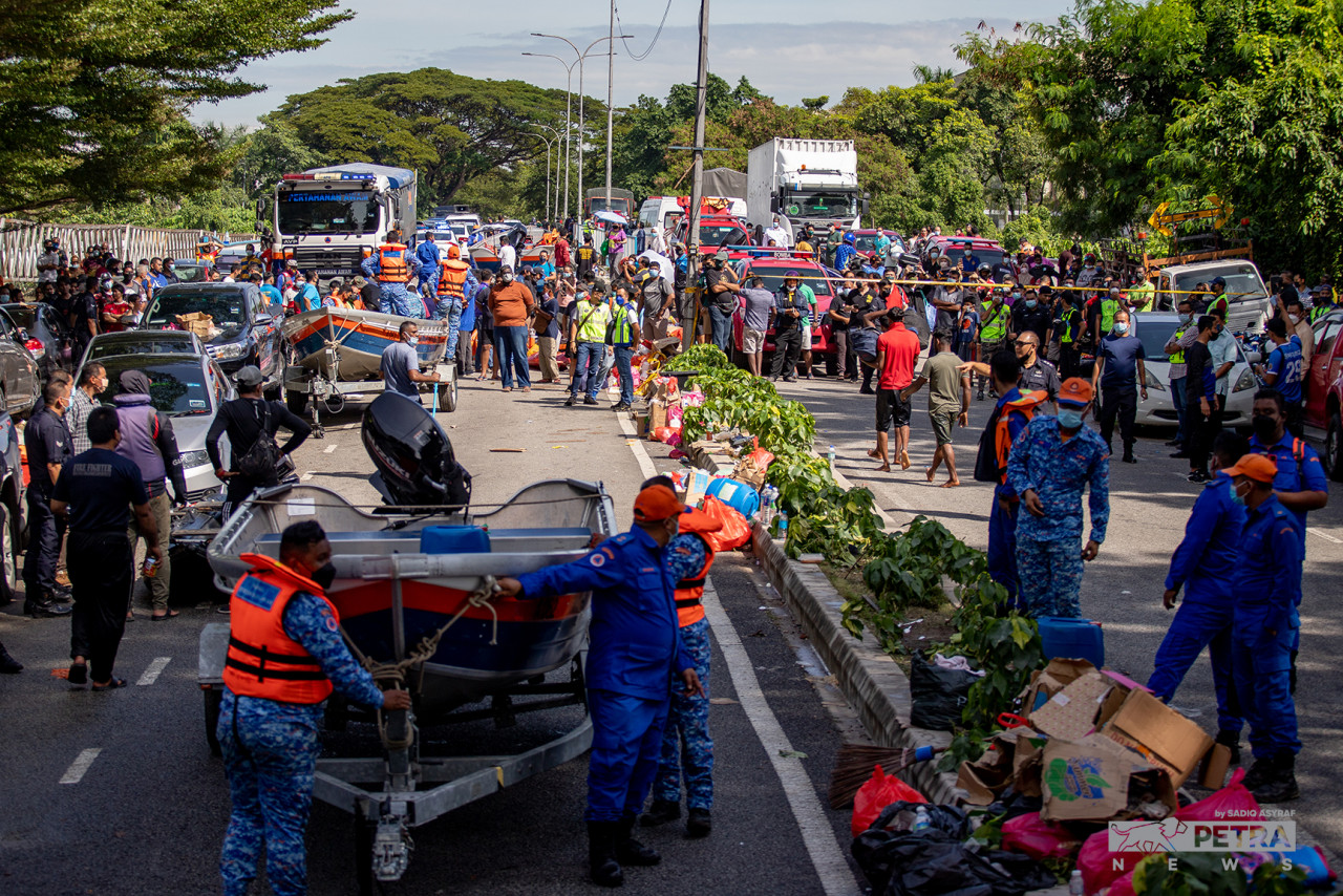 Keadaan di luar pintu masuk ke Taman Sri Muda di mana pasukan menyelamat bertungkus-lumus memindahkan mangsa banjir ke PPS berhampiran.