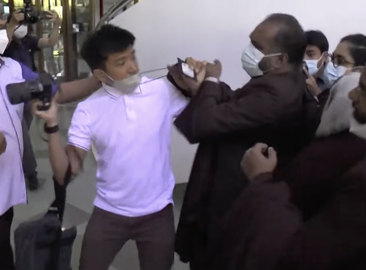 Tangkap layar kekecohan yang berlaku antara jurugambar Utusan Malaysia, Zulfadhli Zaki (kiri) dan peguam S. Suresh di Mahkamah Tinggi Shah Alam, pagi tadi.