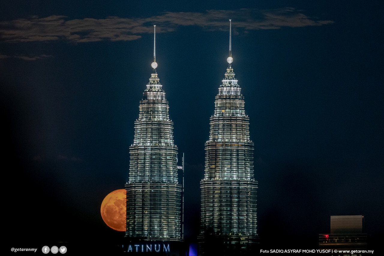 Bulan purnama bersembunyi di sebalik kemegahan bangunan KLCC.