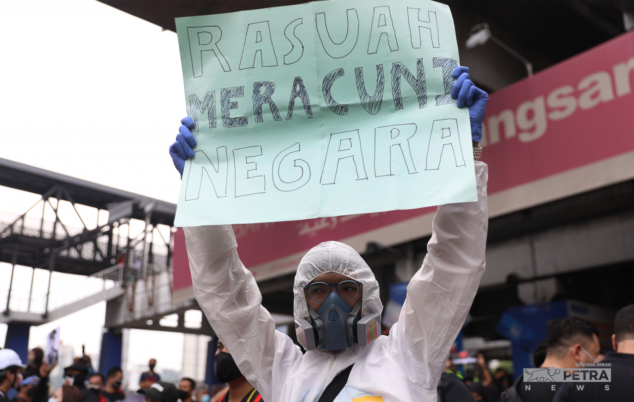 Salah seorang peserta mengangkat sepanduk mengenai rasuah.