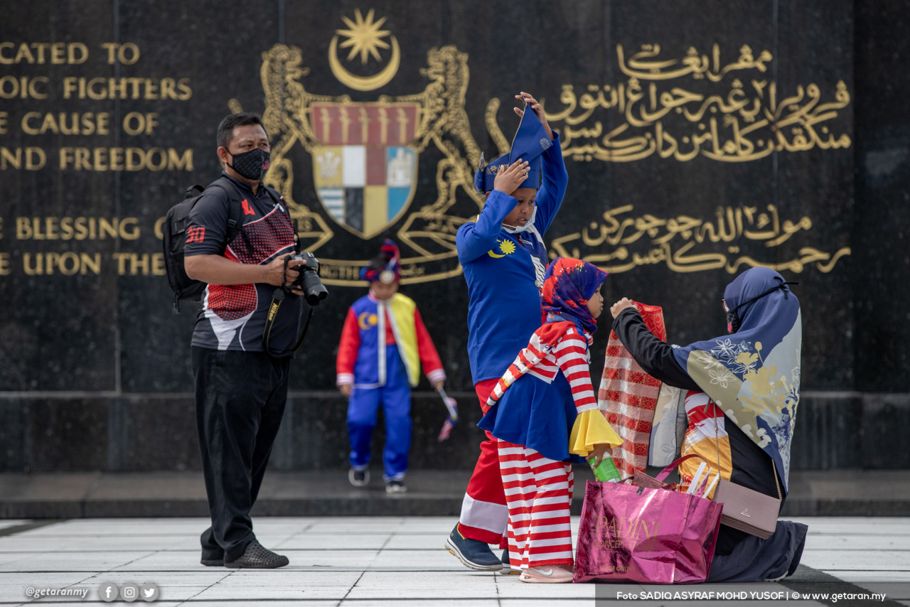 Mohd Noor Shahril dan isteri membawa anak mereka, Ahmad Najeh Syauqi, 12, Ahmad Najid Saufi, 9, dan Naa'ilah Sofiyyah, 5 tahun ke Tugu Negara untuk bergambar bersama busana khas sempena hari kemerdekaan ke-64, di Kuala Lumpur. - Gambar Sadiq Asyraf