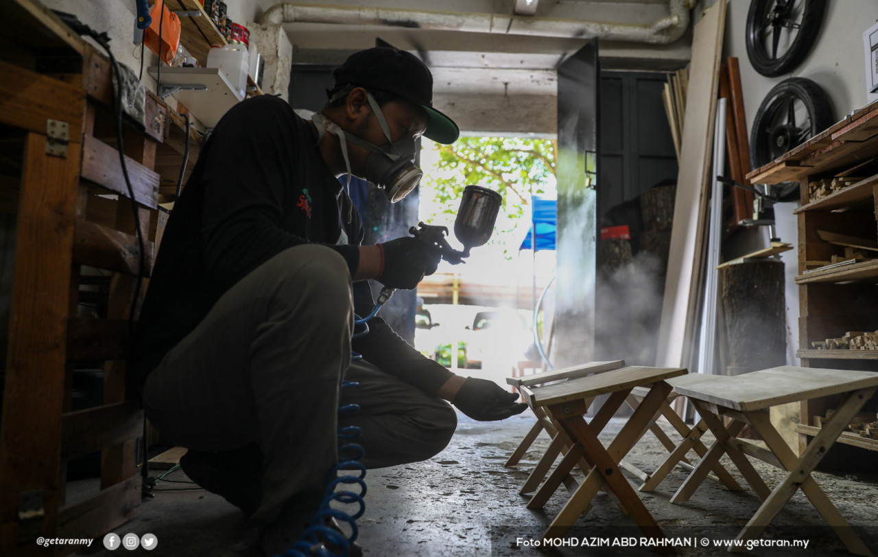 Khairul Helmy menyembur cat pada rehal yang dihasilkannya