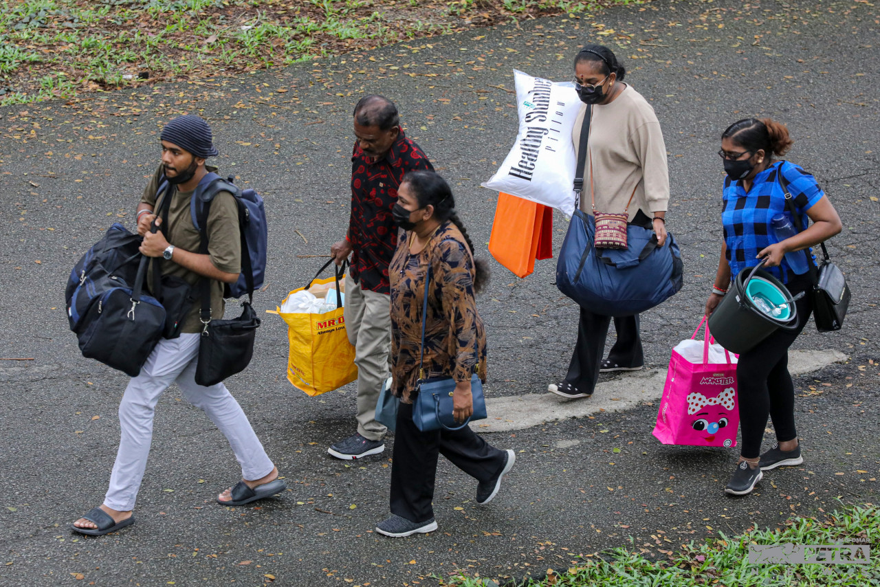 Ahli keluarga membantu pelajar mendaftar membawa barang kelengkapan kolej kediaman