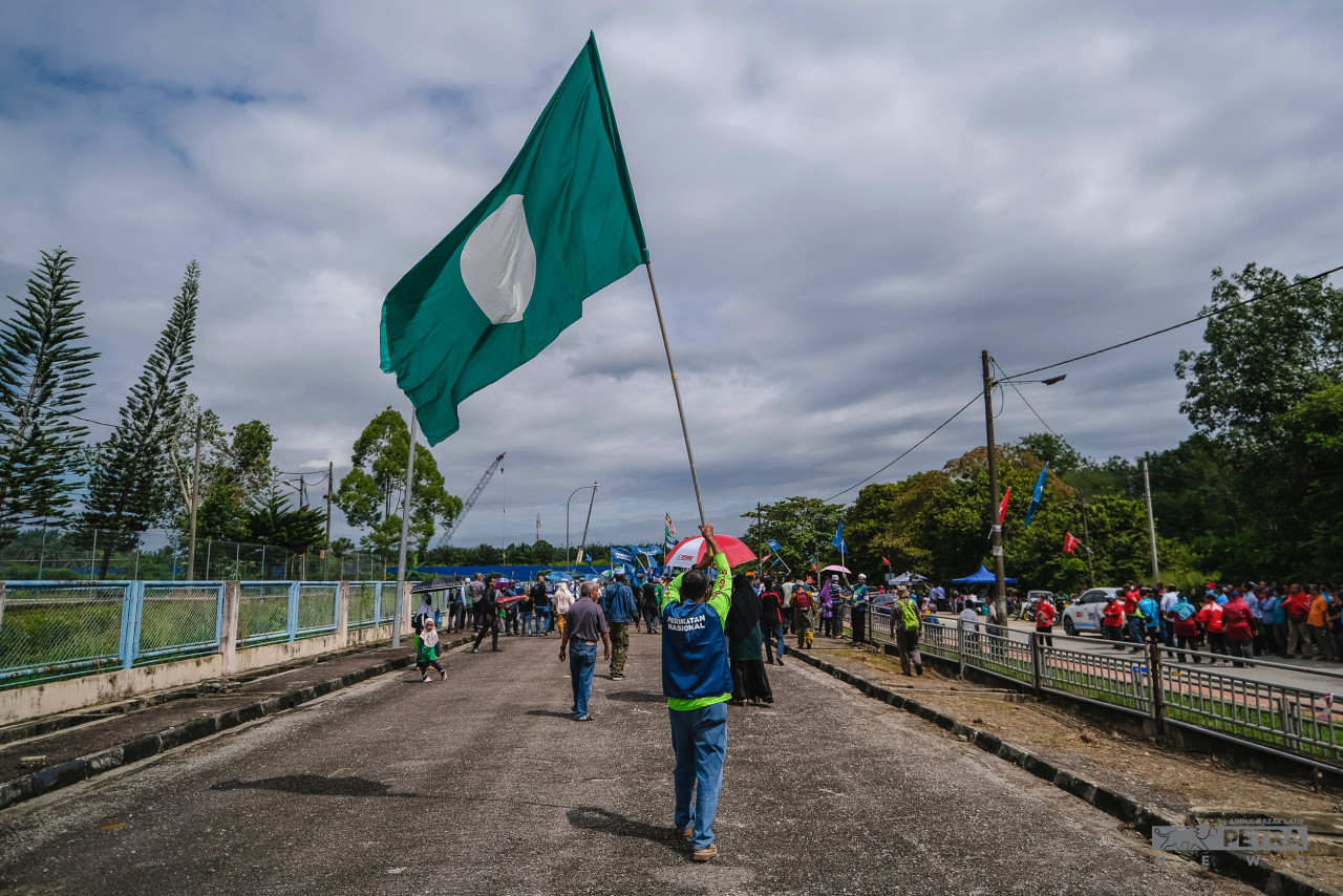 Salah seorang penyokong Perikatan Nasional mengibarkan bendera PAS ketika mengiringi calon parti berkenaan di Pusat Penamaan Calon untuk Parlimen Permatang Pauh. - Gambar oleh Abdul Razak Latif