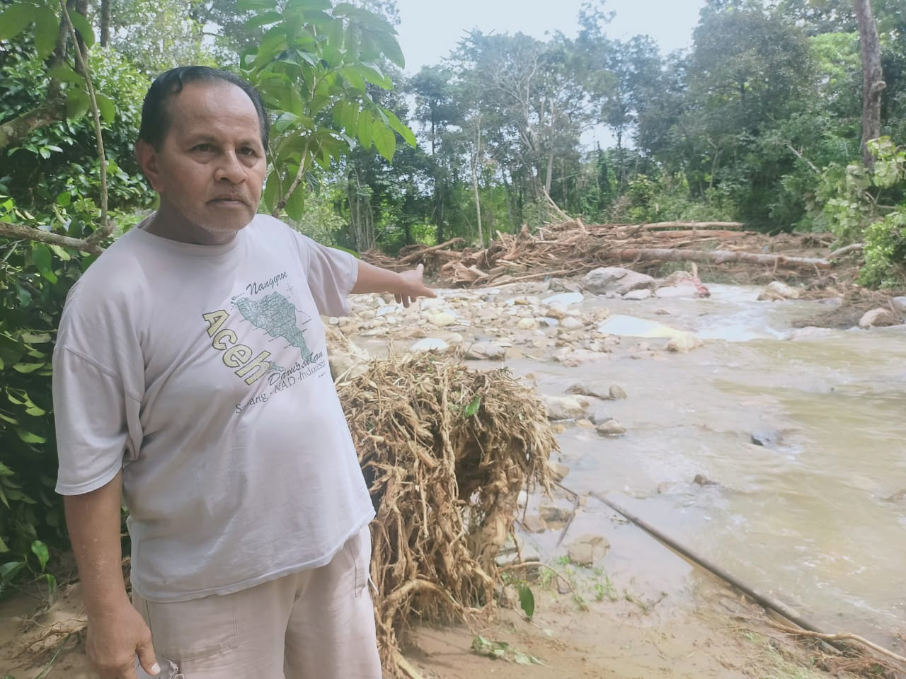 Abdul Nasir Md. Daud menunjukkan serpihan sampah dan pokok yang hanyut ke chalet miliknya.
