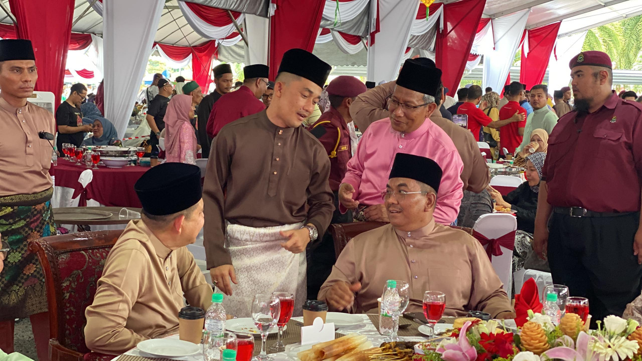 Muhammad Sanusi menyantuni Ahli Dewan Undangan Negeri (ADUN Derga), Muhammad Amri Wahab pada Majlis Rumah Terbuka Aidilfitri Menteri Besar di Seri Mentaloon, hari ini. - gambar Rafisqi Radhi