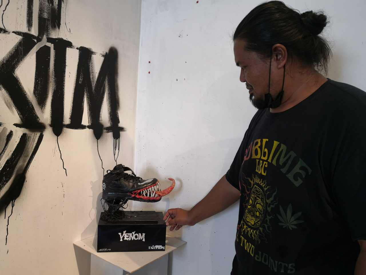 Shahrizad menunjukkan karya Akeem yang diubah suai pada kasut