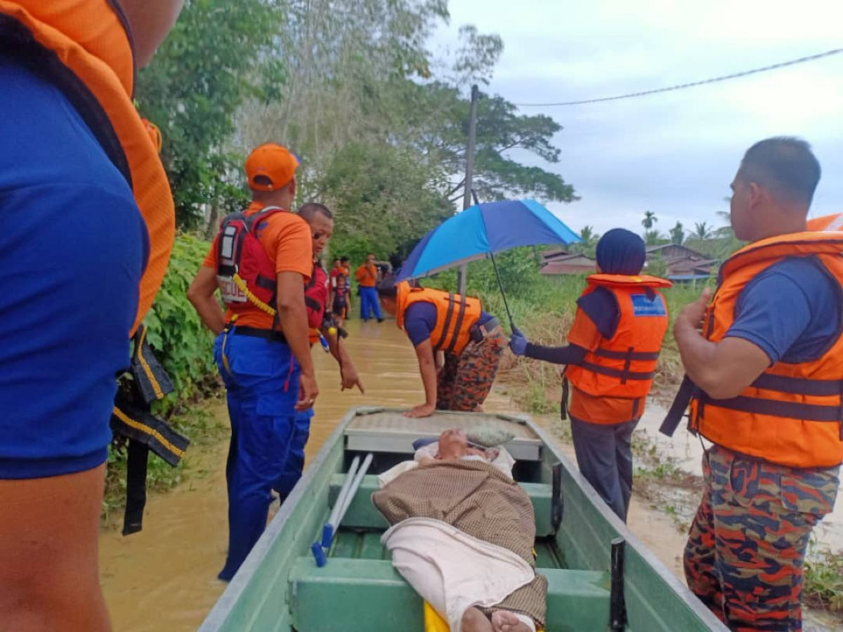 Pasukan penyelamat terpaksa menggunakan perahu bagi memindahkan seorang warga emas yang mengalami keuzuran ke PPS berhampiran.
