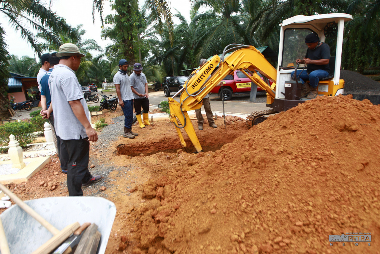 Jengkaut memudahkan kerja-kerja menggali liang lahad. gambar Azlan Hadi Abu Bakar