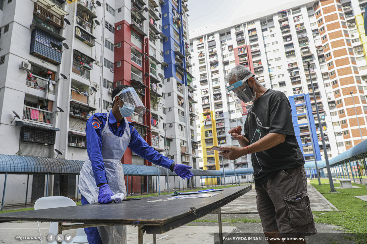 Seorang petugas DBKL membantu pendaftaran untuk ujian saringan COVID-19 di Kuala Lumpur.