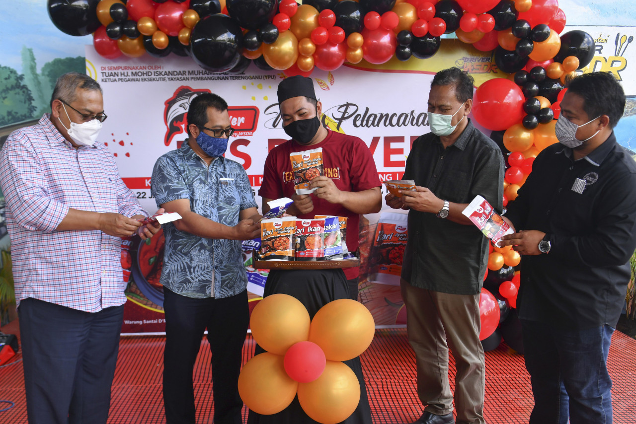 Ketua Pegawai Eksekutif Yayasan Pembangunan Usahawan (YPU) Terengganu Mohd Iskandar Muhammad Aziz (dua, kiri) bersama pemilik kedai Abdul Mutalib Mohamad, 38 ,(tengah) melihat beberapa jenis paket pes pada Majlis Pelancaran Pes D'River