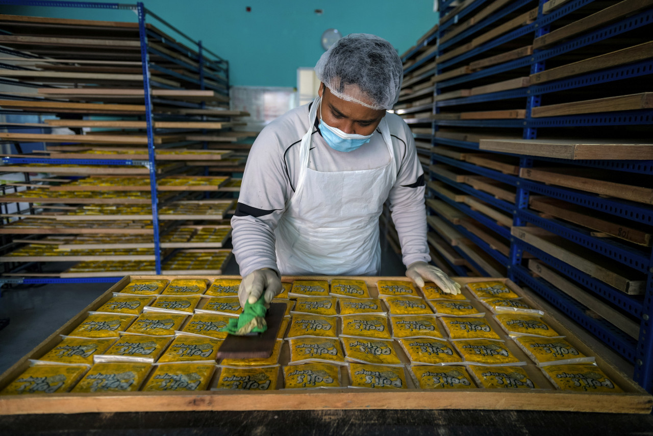 Pekerja menekan paket plastik tempe yang akan diperam selama dua hari sebelum boleh dijual