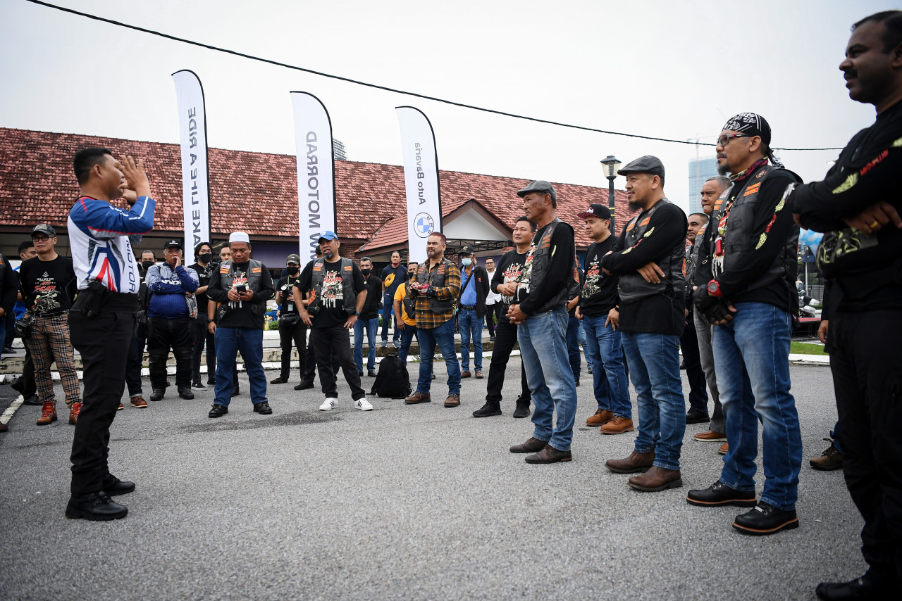 Peserta konvoi ‘Awie Ride 2022’ melakukan senaman regangan sebelum memulakan konvoi sempena Kempen Anti Scam JSJK, di Pulapol, hari ini. - Gambar Bernama