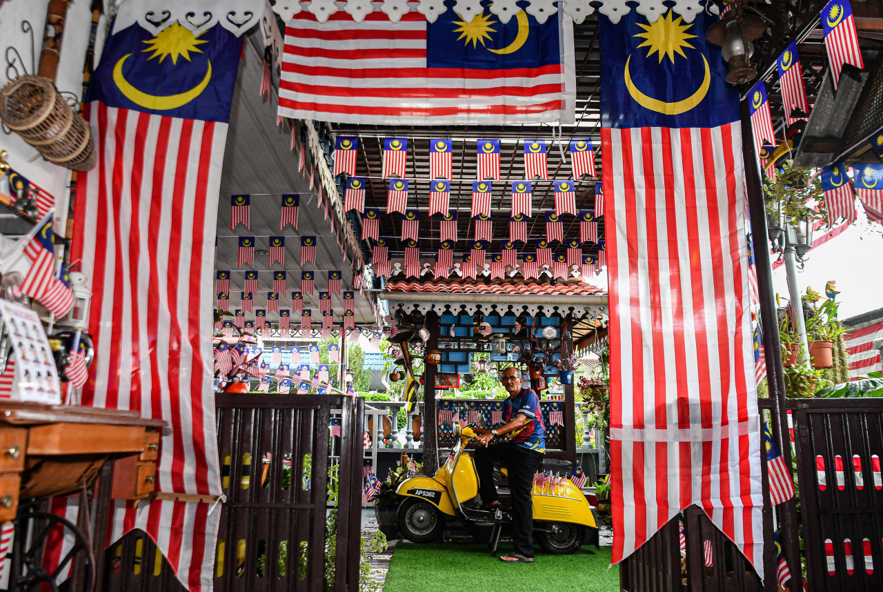 Warga Perak, Jaafar Othman, 61, bergambar di skuter miliknya yang dihiasi dengan Jalur Gemilang menjelang sambutan hari kebangsaan - Gambar Bernama