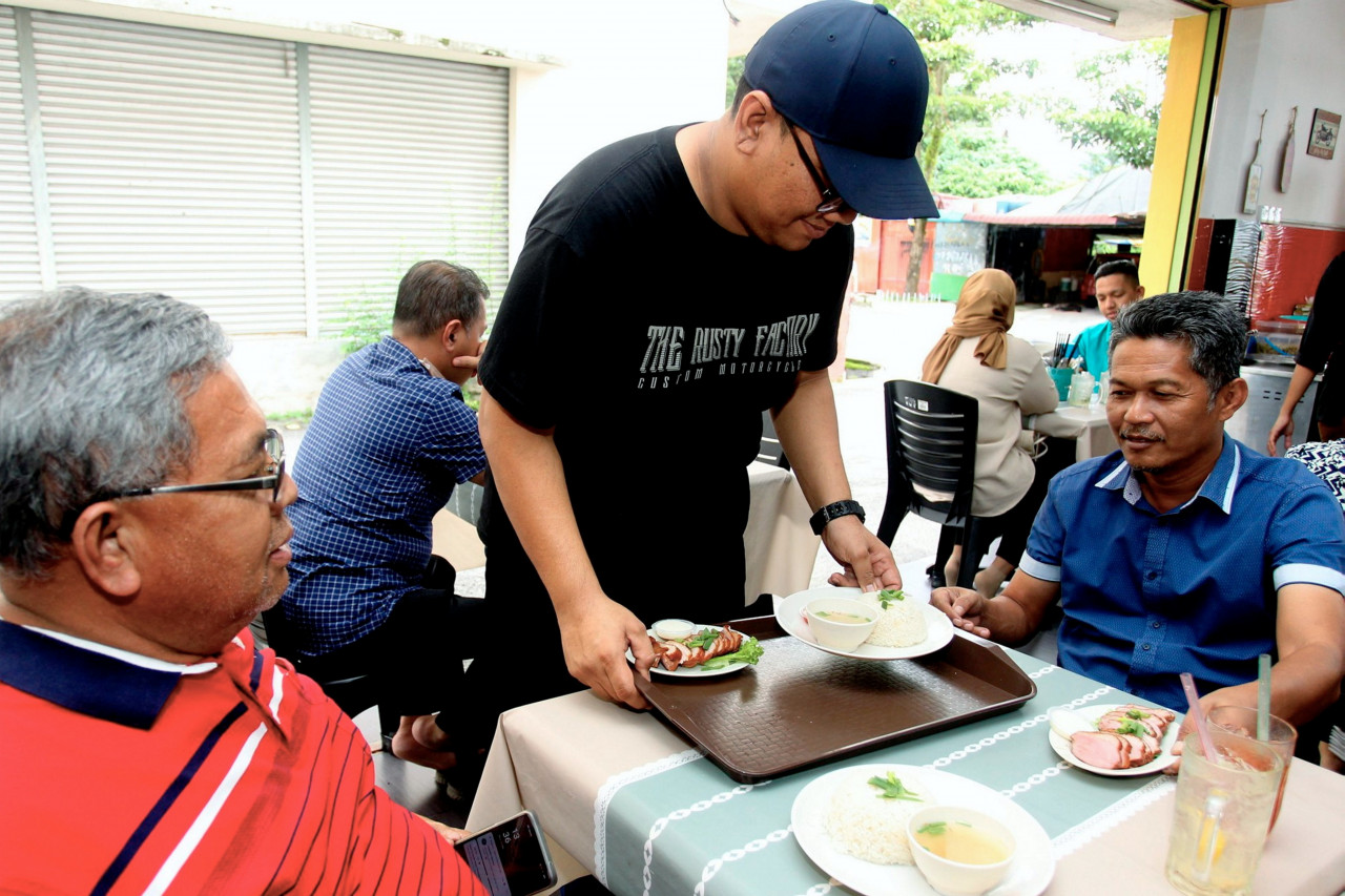 Razman Nazrin Shah sibuk melayan pelanggan tetapnya. - Gambar Bernama