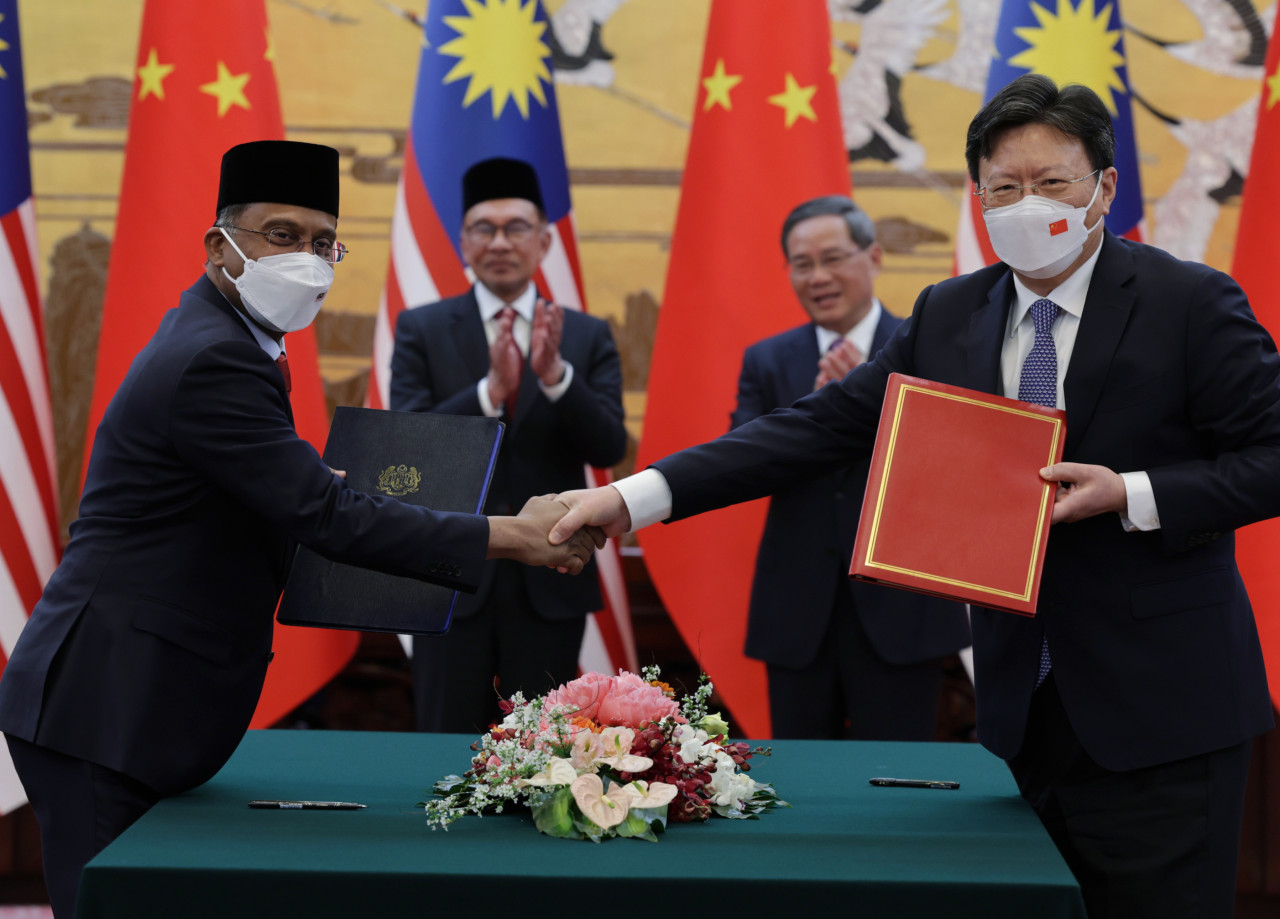 Anwar Ibrahim (belakang, dua kiri) dan rakan sejawatnya Li Qiang (belakang, dua, kanan) menyaksikan pertukaran dokumen Memorandum Persefahaman (MoU) Protocol of Phytosanitary Requirement for the Exportation of Jackfruit to China di antara Kementerian Pertanian dan Keterjaminan Makanan dari Malaysia (MAFS) diwakili Zambry Abdul Kadir (kiri) dan Minister of the General Administration of Customs of China Yu Jianhua (kanan) di Great Hall of the People hari ini. - Gambar Bernama