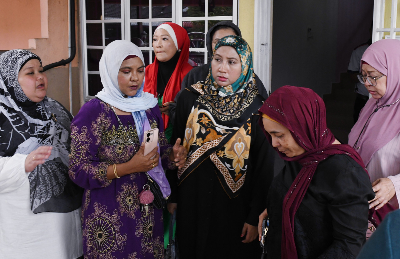 Norhayati Zulkaply (dua, kanan) ditemani rakan-rakannya di sebuah rumah inap desa di Taman Pauh Jaya di sini, hari ini. gambar BERNAMA