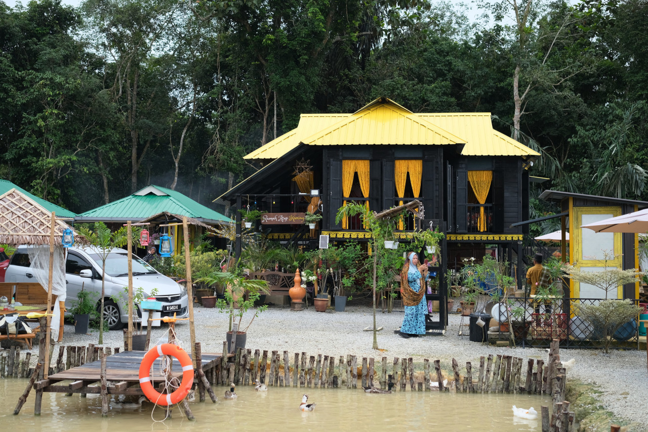 Pengunjung Rumah Atap Kuning mengambil peluang untuk bergambar di persekitaran rumah ketika tinjauan Bernama di Bukit Lada Sayong baru-baru ini. – gambar BERNAMA 