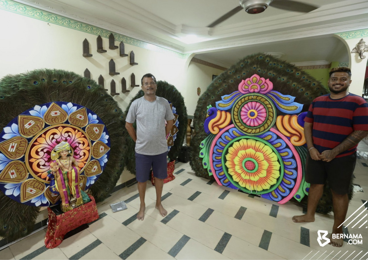Pembuat kavadi K. Selvaraja bersama seorang daripada anaknya yang turut sama meneruskan tradisi masyarakat India menghasilkan kavadi bulu merak. - gambar BERNAMA 