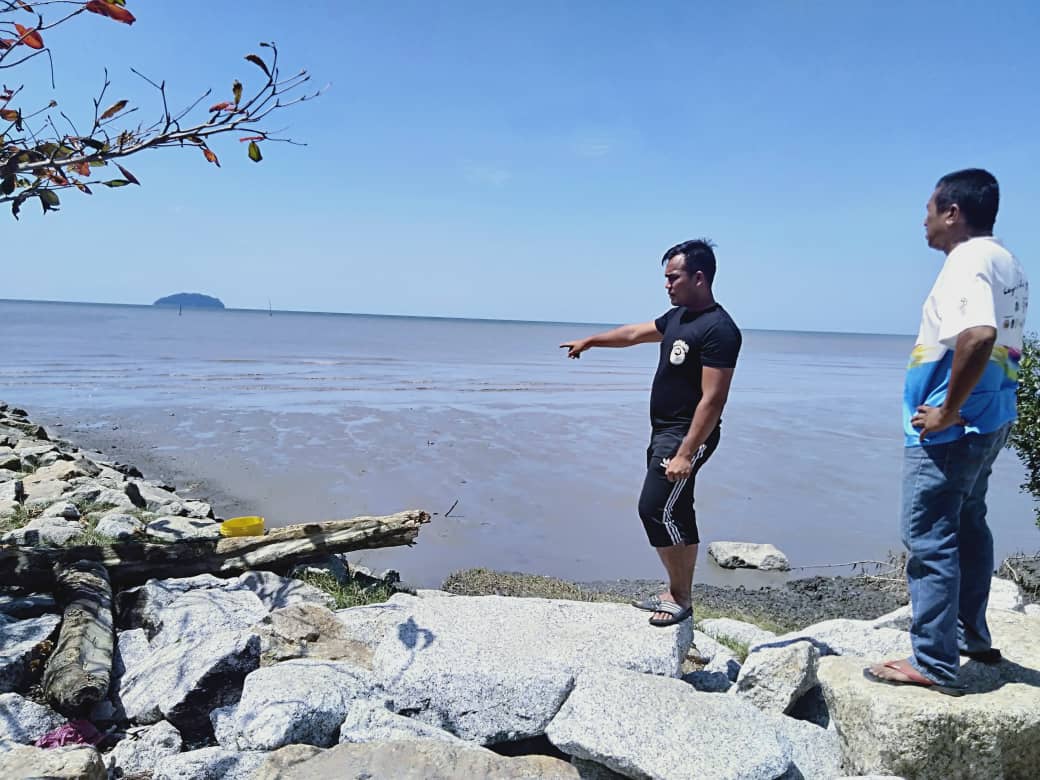 Zafri Aiman Jalmen menunjukkan lokasi sekumpulan PATI dilihat meniti atas batu penghadang ombak. - gambar Rafisqi Radhi
