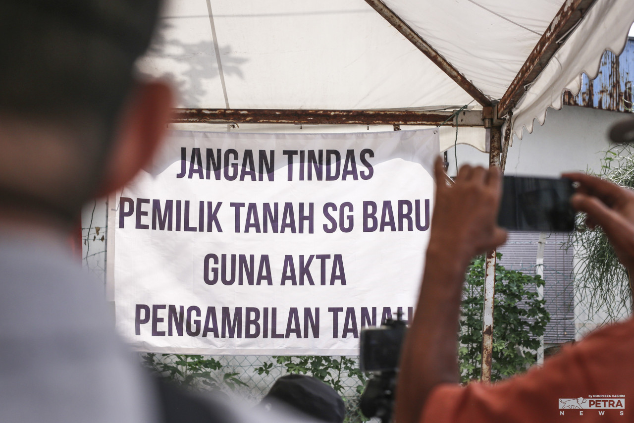 Kain rentang dinaikkan oleh penduduk Kampung Sungai Baru yang membantah pengambilan tanah. - Gambar fail