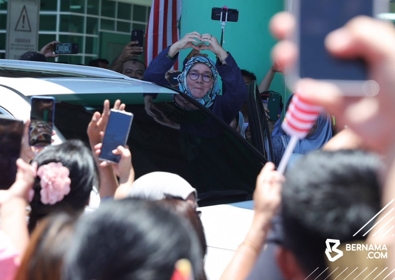 Raja Permaisuri Agong Tunku Azizah Aminah Maimunah Iskandariah menunjukkan lambang hati kepada rakyat Sarawak yang menanti ketibaan Yang di-Pertuan Agong Al-Sultan Abdullah Ri'ayatuddin Al-Mustafa Billah Shah dan baginda sempena Kembara Kenali Borneo. - gambar BERNAMA