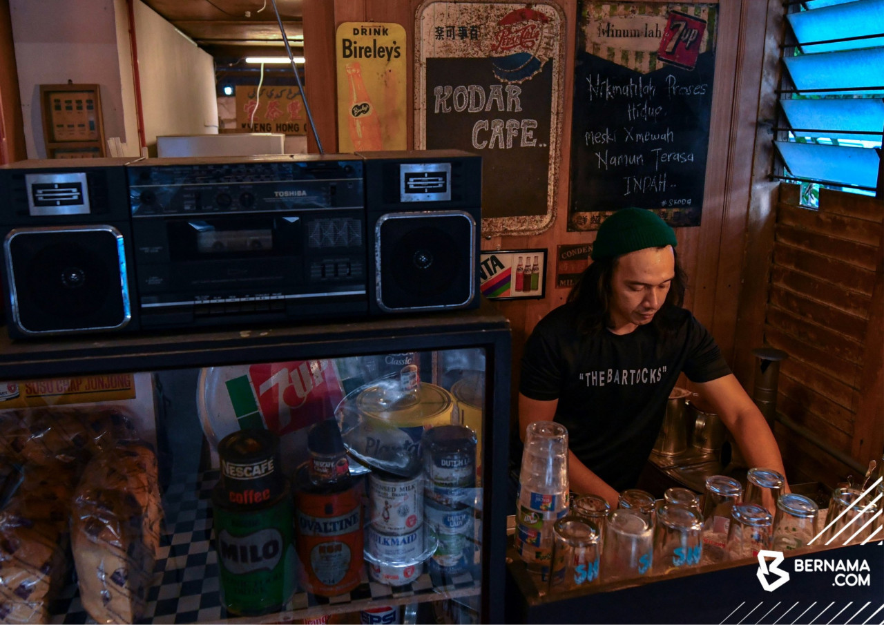 Radio lama dan almari kaca mempamerkan tin susu, milo serta roti antara susun atur yang nampak 'retro'. - gambar BERNAMA