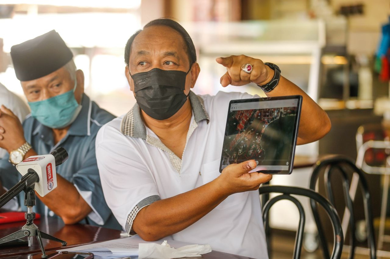 Muhamad Farid Saad menunjukkan peta rancangan pembinaan asrama pekerja asing berskala mega di Bayan Lepas, hari ini.