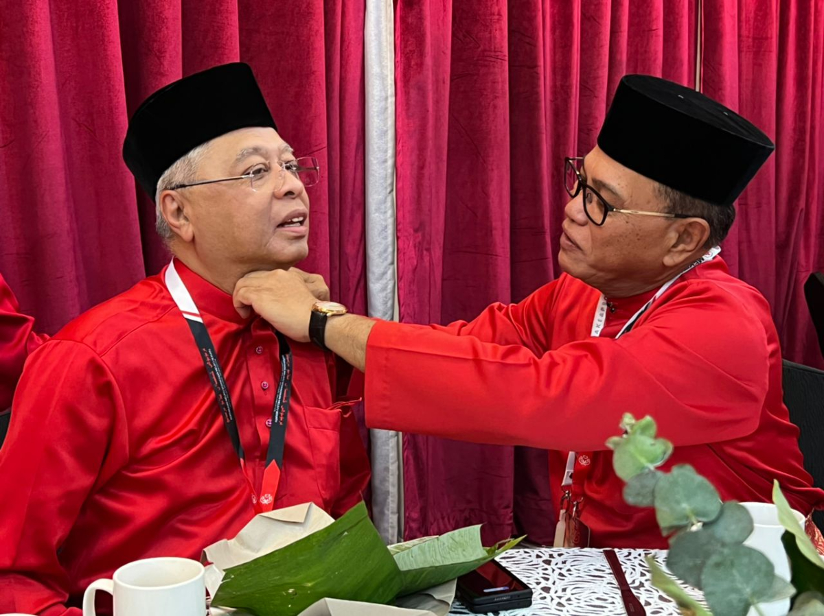 Menteri Besar Pahang, Datuk Seri Wan Rosdy Wan Ismail membetulkan butang baju Melayu Perdana Menteri, Datuk Seri Ismail Sabri Yaakob sebelum acara menaikkan bendera UMNO di WTC, Kuala Lumpur pagi ini.