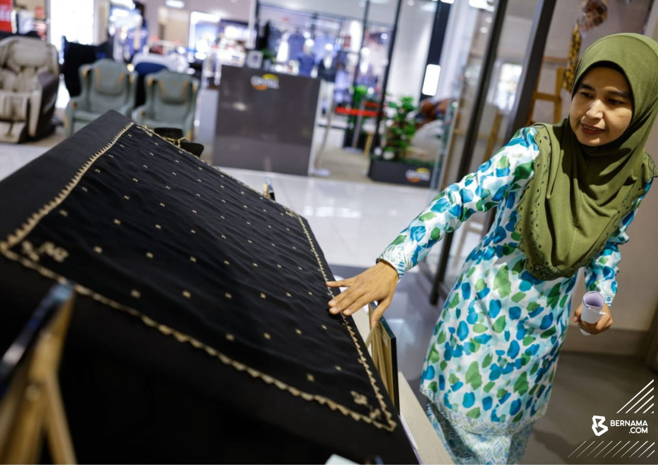 Tengku Intan Rahimah menunjukkan antara tekstil yang dipamerkan. - gambar BERNAMA