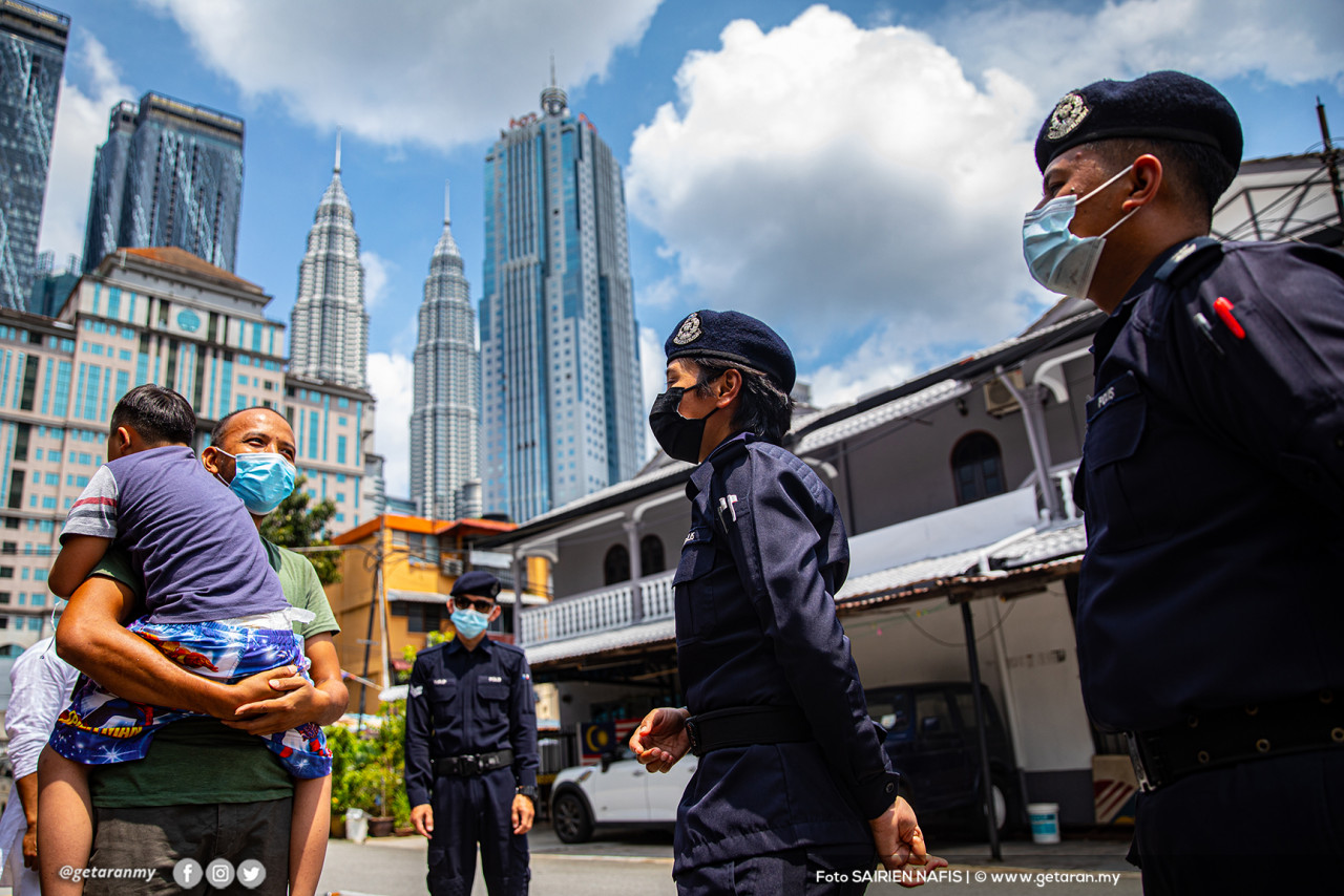 Inspektor Ilyana Mohd Badrai (dua dari kanan) dari Bahagian Siasatan Jenayah bersama anggota IPD Dang Wangi membuat pemantauan dan pemeriksaan rumah ke rumah ketika Aidilfitri bagi memastikan tiada aktiviti kunjung-mengunjung di sekitar Kampung Baru, Kuala Lumpur.