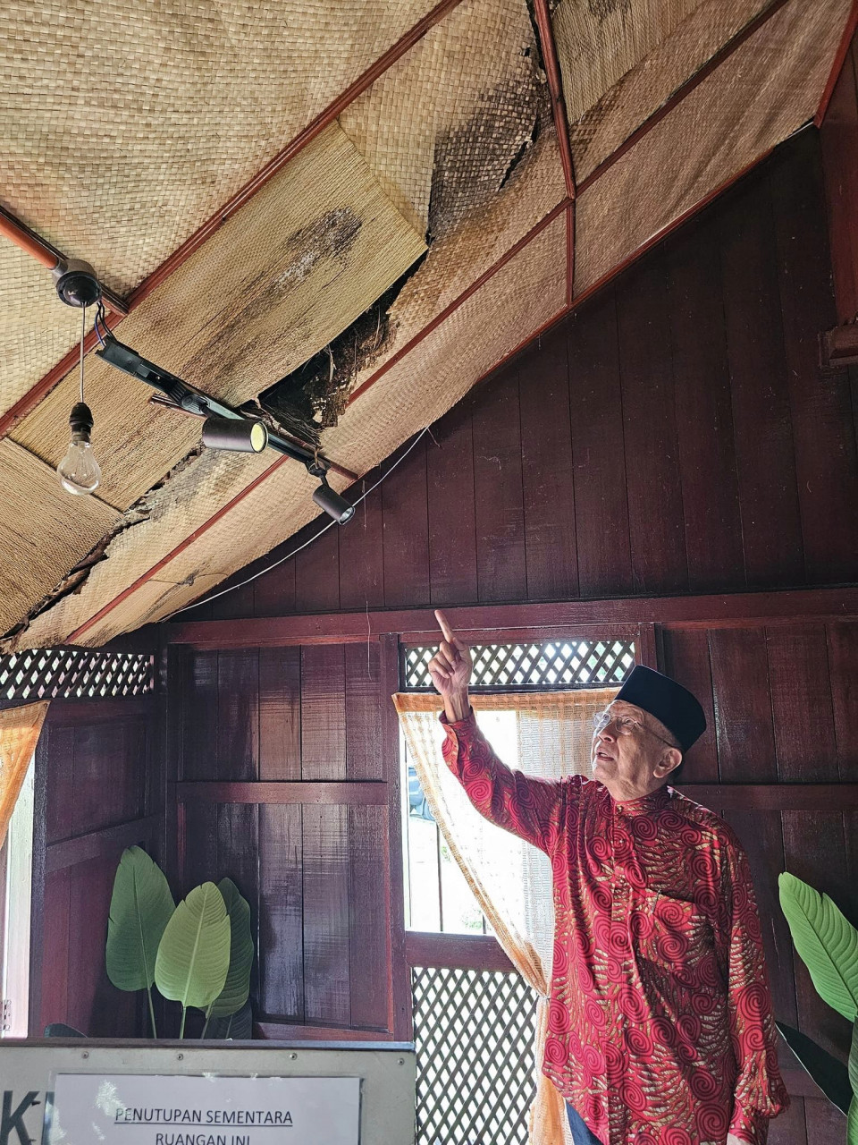 Rais menunjukkan kesan kebocoran pada siling di rumah kelahiran P. Ramlee yang kini dijadikan muzium. - gambar Facebook Rais Yatim