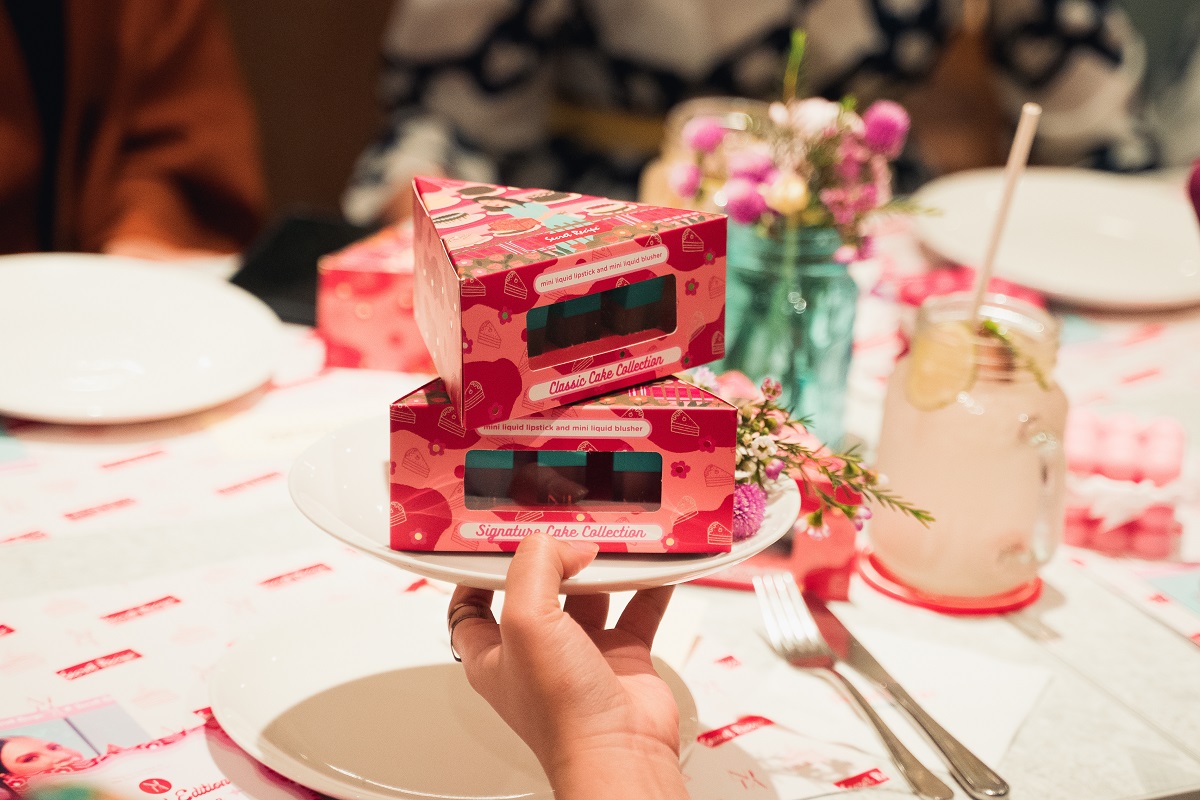 Konsep pembungkusan retro, dengan kotak berbentuk potongan kek berwarna merah jambu menyerlahkan lagi ilustrasi yang ceria. - Gambar Secret Recipe X Nita Cosmetics