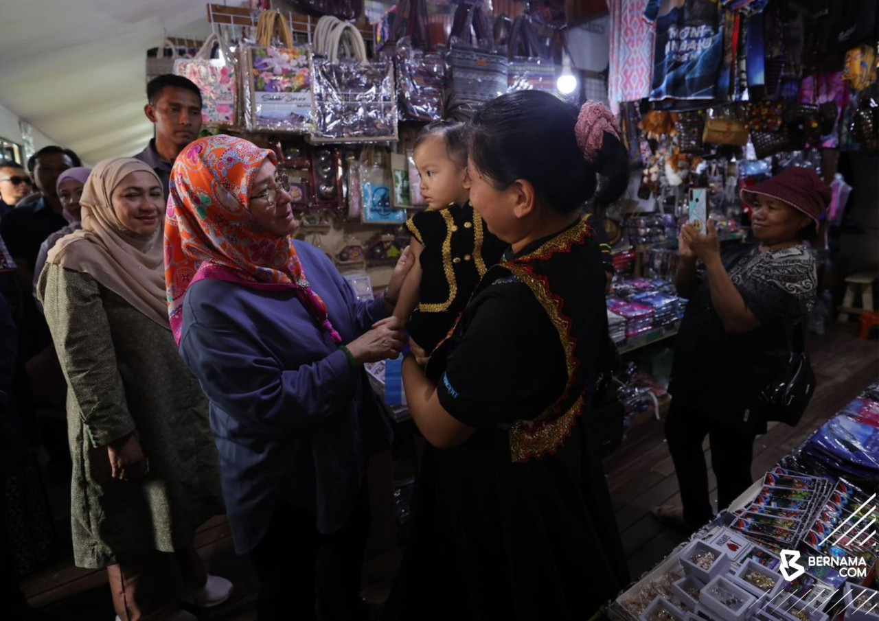Raja Permaisuri Agong Tunku Azizah Aminah Maimunah Iskandariah berkenan beramah mesra dengan peniaga dan pengunjung di Pekan Nabalu. - gambar BERNAMA
