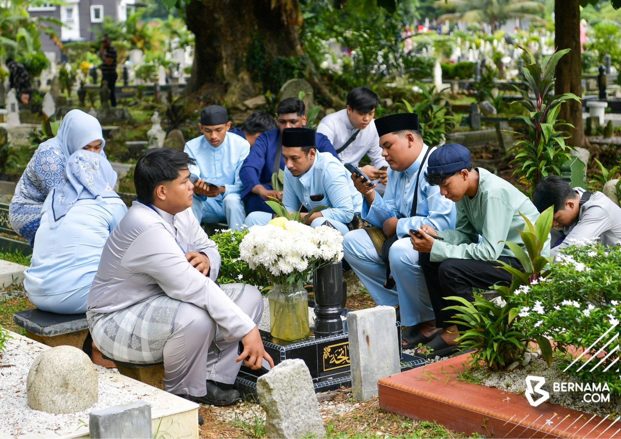 Umat Islam menziarahi kubur saudara mara mereka sempena Aidilfitri di Tanah Perkuburan Islam Jalan Ampang hari ini. - gambar BERNAMA